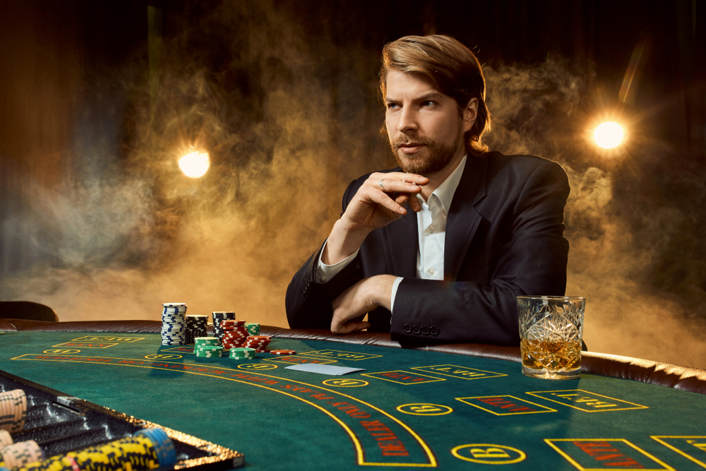 man in a suit sitting at a poker table